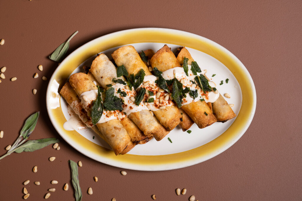 Taquitos végétaliens servis dans une assiette avec salsa